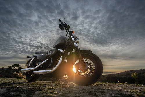 a motorcycle parked on the side of a dirt field